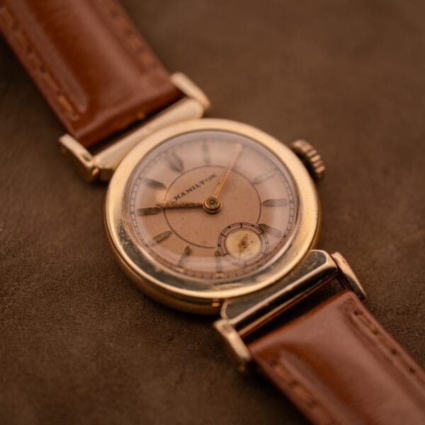 Hamilton Prescott salmon dial and scarab case angled glamour shot on suede