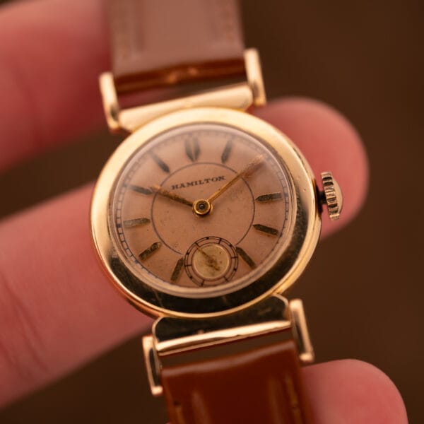 Hamilton Prescott salmon dial in hand with HAMILTON wordmark and sub-seconds register
