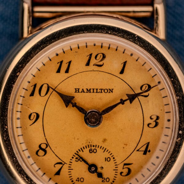 1936 Hamilton Randolph macro dial detail showing HAMILTON wordmark, Art Deco Arabic numerals, blued cathedral hour and minute hands, and sub-seconds register