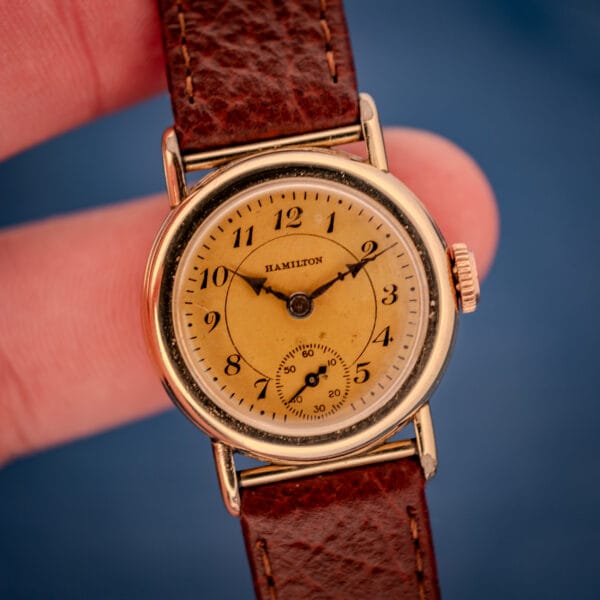 1936 Hamilton Randolph held in hand showing full Art Deco cream dial, cathedral hands, and signed rose-toned crown