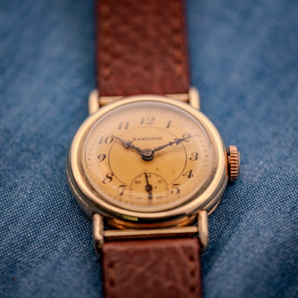 1936 Hamilton Randolph dial-up on blue textile showing 27.6mm gold filled case and brown leather strap fitment