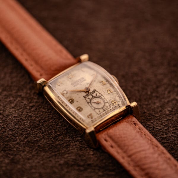Gruen Precision Ref. 430-457 hero angle, tan leather strap on dark backdrop