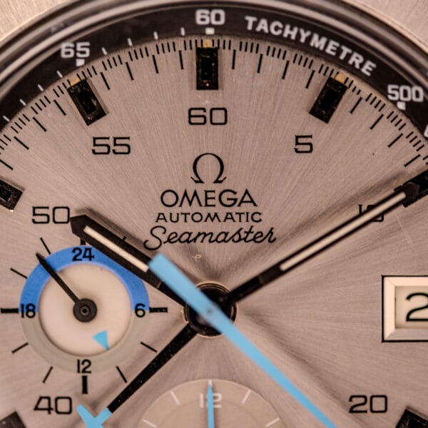 Omega 176.007 dial macro showing OMEGA Automatic Seamaster signature and sky-blue 24-hour totalizer at 9 o'clock