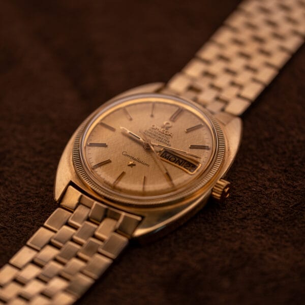 Omega Constellation Ref. 168.029 vintage gold day-date Chronometer watch with linen dial photographed against brown suede