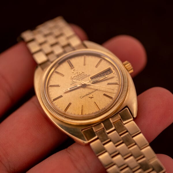 Omega Constellation 168.029 in hand at angle showing fluted bezel and cushion case silhouette with day-date at three