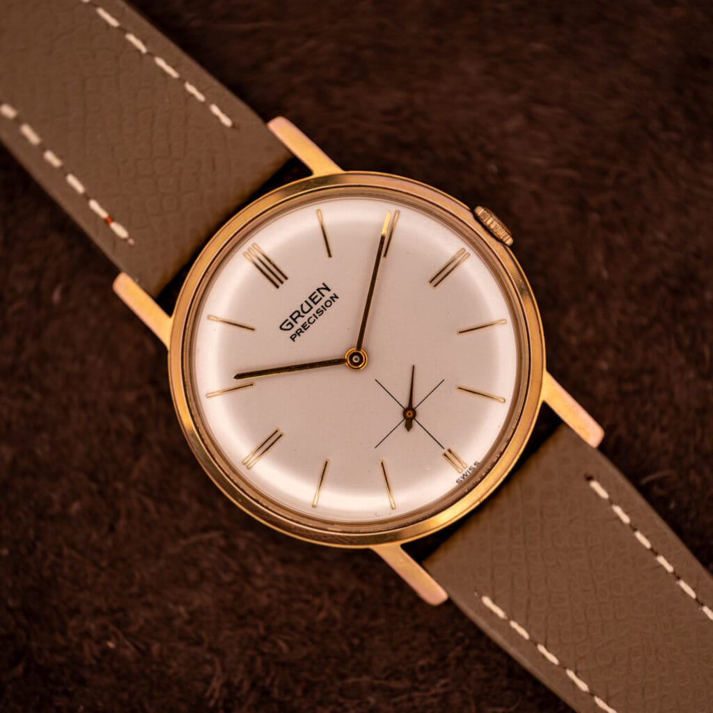 Vintage Gruen Precision 510 cream dial with gold dauphine hands and 12 3 6 9 triple-line markers on grey saffiano strap