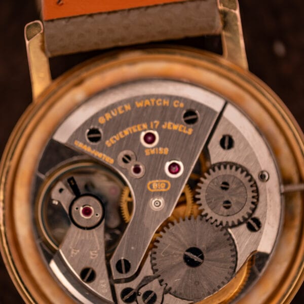 Gruen Precision caliber 510 movement bridge macro with GRUEN WATCH Co signature, UNADJUSTED stamp, and 510 cartouche