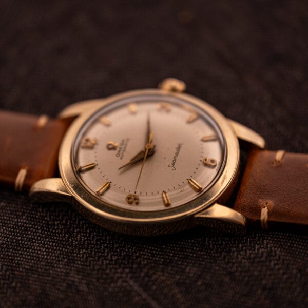 Omega Seamaster GX 6250 angled overhead view showing dial, scarab lugs, and Omega-signed crown