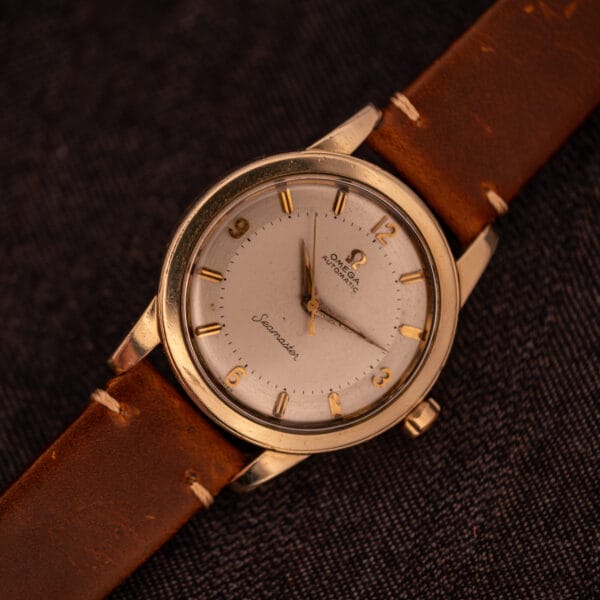 Omega Seamaster GX 6250 wrist-orientation view on brown leather strap against dark background