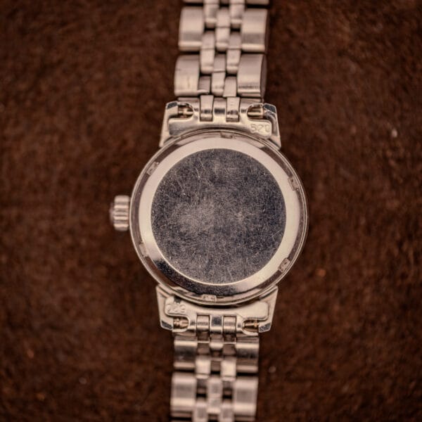 Outer caseback of Omega Ladymatic 566.002 in brushed stainless steel showing honest unrefinished surface wear