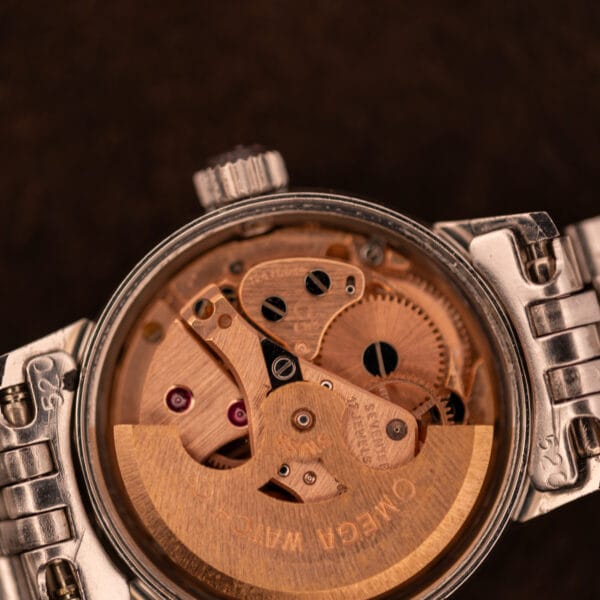Macro of Omega caliber 681 movement showing copper-plated bridge work, ruby jewels, and OMEGA WATCH CO rotor signature