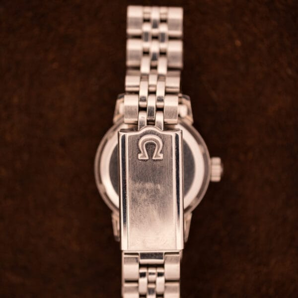 Top of Omega Ladymatic 566.002 folding clasp with raised Omega logo on the signed steel cover plate