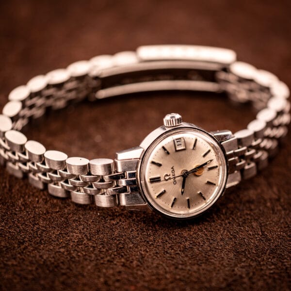 Angled hero shot of Vintage Omega Ladymatic 566.002 on its period steel beads-of-rice bracelet on brown leather