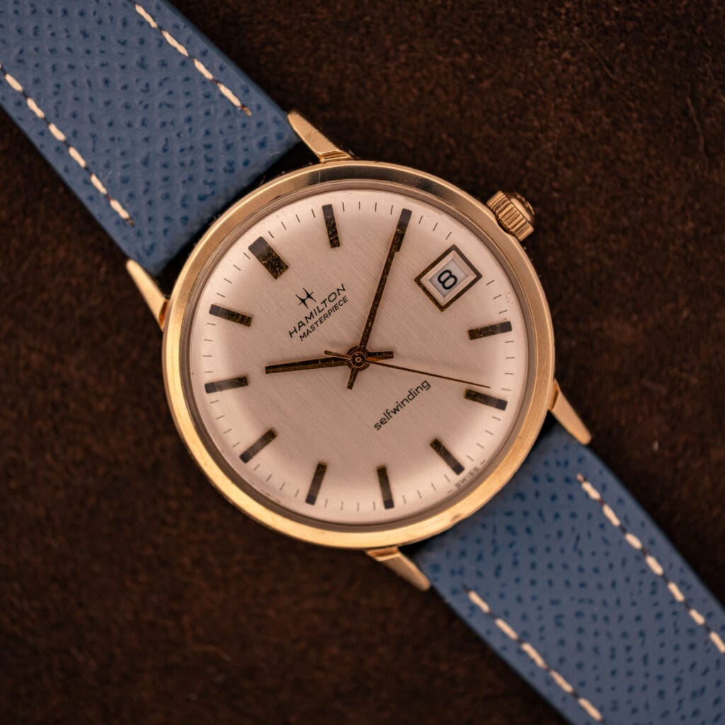 Vintage Hamilton Masterpiece silver sunburst dial top-down with date at three on blue Saffiano leather strap