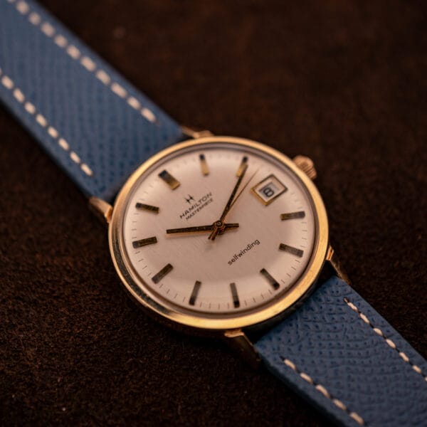 Vintage Hamilton Masterpiece round 34mm gold filled case shown three-quarter with blue Saffiano strap and cream contrast stitching