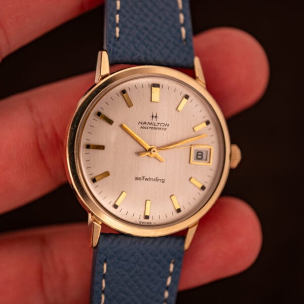 Hamilton Masterpiece on blue Saffiano strap with orange leather lining peeking through at the strap edge