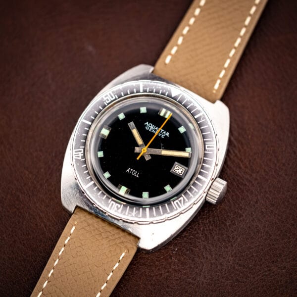 Aquastar Geneve Atoll 1001 stainless steel cushion case three-quarter view on grey leather strap