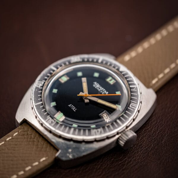 Aquastar Atoll 1001 low three-quarter shot on leather with full bezel countdown markings visible
