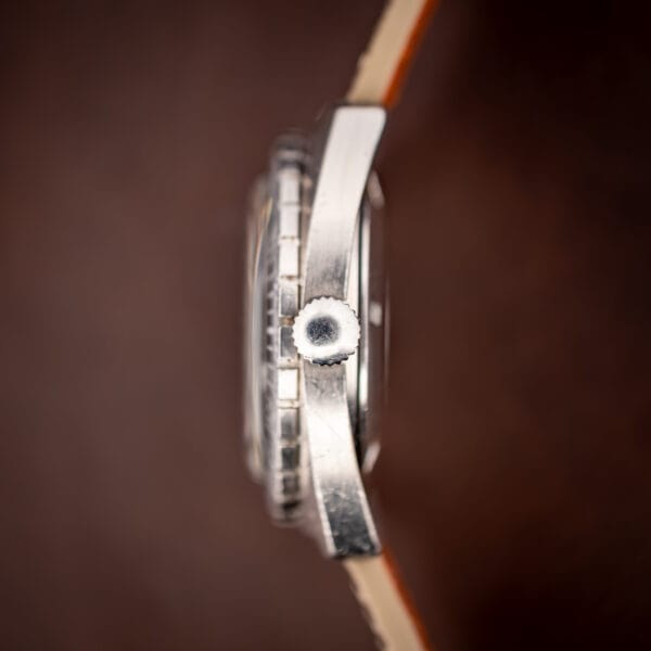 Aquastar Atoll 1001 crown side profile macro showing the unsigned coin-edge crown and case flank