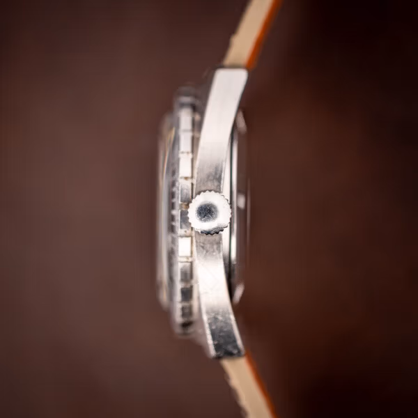 Aquastar Atoll 1001 crown side profile macro showing the unsigned coin-edge crown and case flank