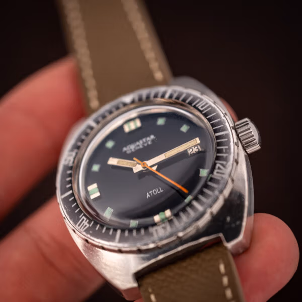 Aquastar Atoll 1001 hand-held angled view with crown and ghosted dive bezel in focus