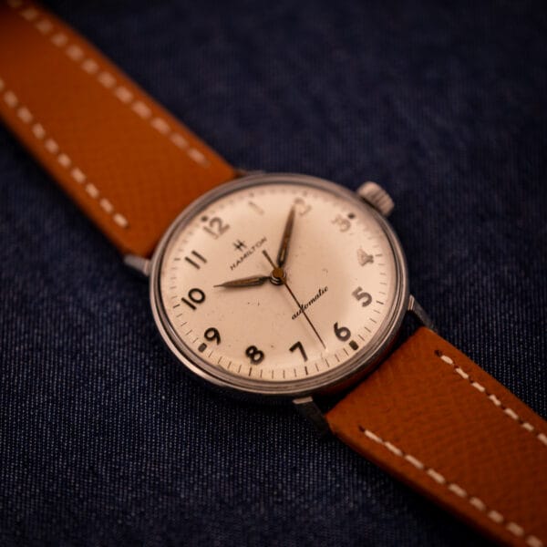 Hamilton Accumatic A-507 33mm stainless steel case shown three-quarter on tan saffiano leather strap