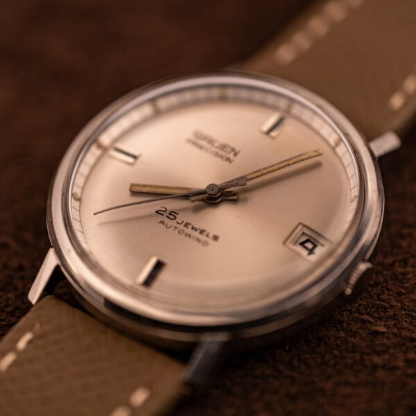 Vintage Gruen Precision Autowind angled hero shot with date window and Gruen-signed crown at three