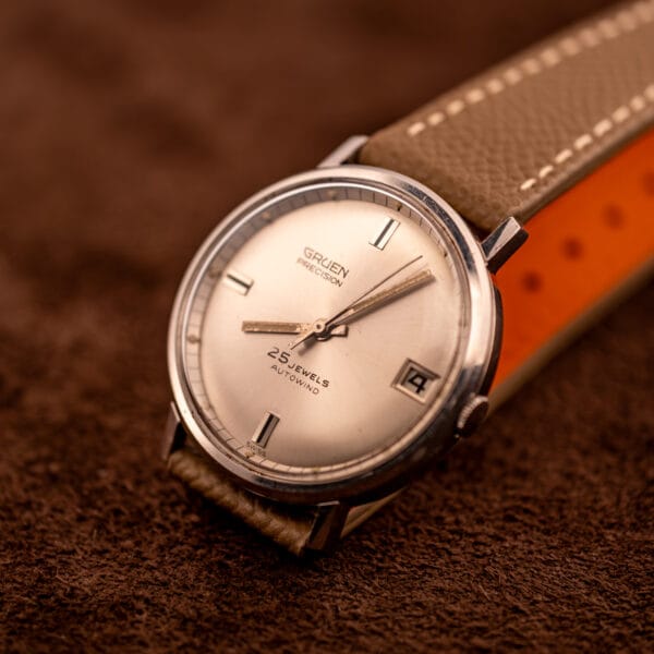 Vintage Gruen Precision angled dial view with applied chrome baton markers and date window detail