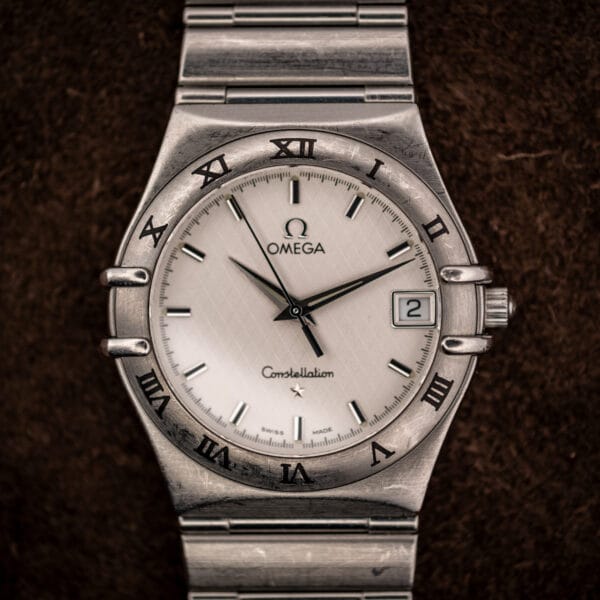 Omega Constellation Quartz 1512.30 straight-on view of the full watch and bracelet on brown suede background