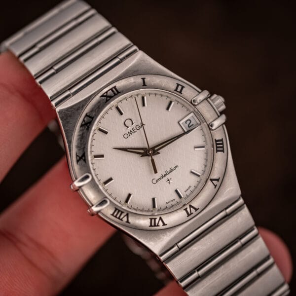 Omega Constellation 1512.30 in hand on a fingertip, full dial visible with Roman-numeral bezel and integrated 1552/862 bracelet