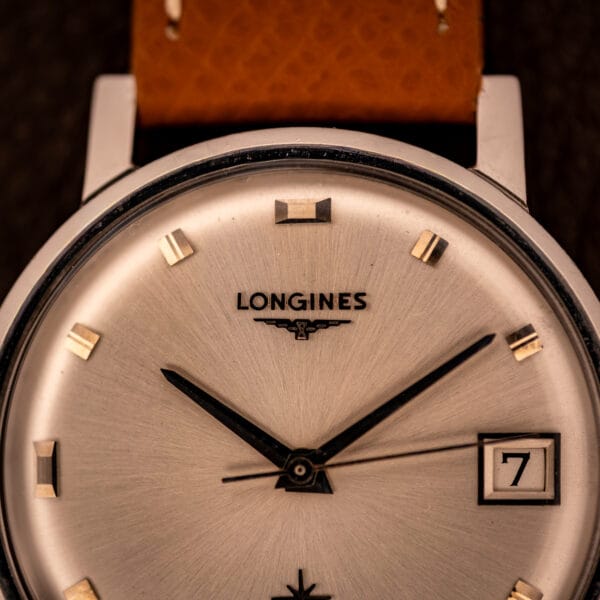 Longines Flagship 2821-285 dial close-up showing applied LONGINES winged hourglass logo and faceted gold-tone baton hour markers