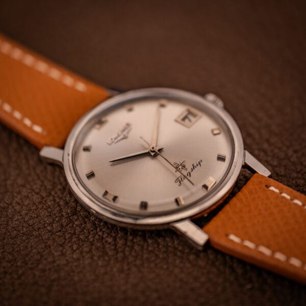 Longines Flagship 2821-285 three-quarter view showing the slim 35mm stainless steel case and polished lyre lugs from a moody angle