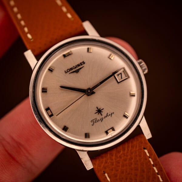 Hand-held shot of the Longines Flagship reference 2821-285 showing the 35mm steel case proportion against the wearer's hand