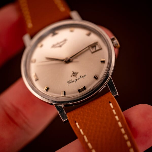 Close hand-held dial view of the Longines Flagship 2821-285 with the date window framing a clean numeral seven