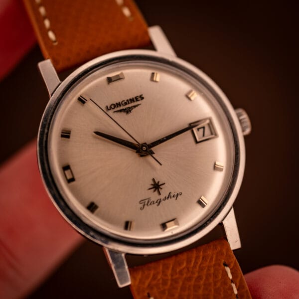 Macro of the Longines Flagship 2821-285 silver sunburst dial and applied gold baton markers under warm directional light