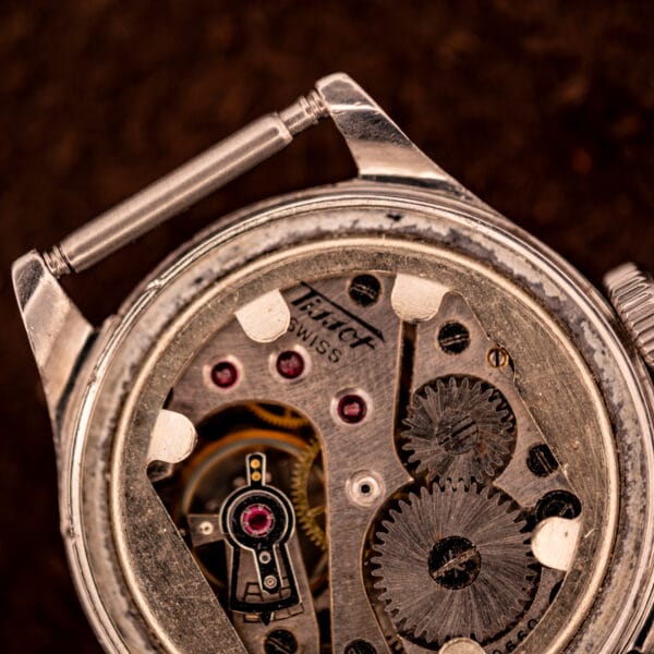 Tissot caliber 27 full movement view showing balance wheel, ruby jewels, and jeweled bridge inside the Aquasport stainless case