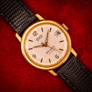 Vintage Gruen Precision automatic on black lizard strap, silver sunburst dial, applied gold Arabic 12-6-9, date at three