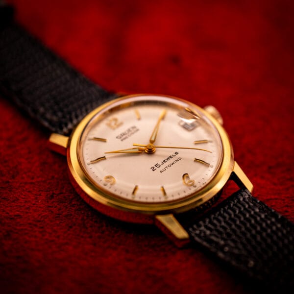 Vintage Gruen Precision automatic watch dial fully visible, applied gold Arabic 9 12 6, dauphine hands, gold-tone case bezel