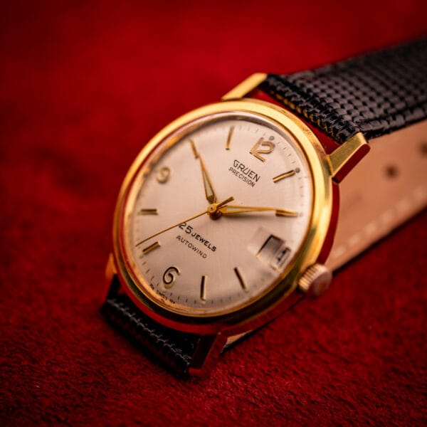 Vintage Gruen Precision dramatic three-quarter, silver sunburst dial catches light, gold dauphine hands and applied numerals