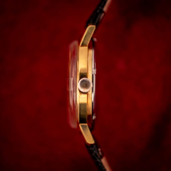 Vintage Gruen Precision case profile close-up, gold-plate bezel and lugs, original crown at three, double-domed acrylic crystal