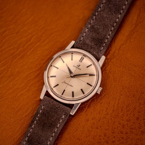 Vintage Omega Seamaster reference 135.005 three-quarter view on amber leather background, crown at three visible