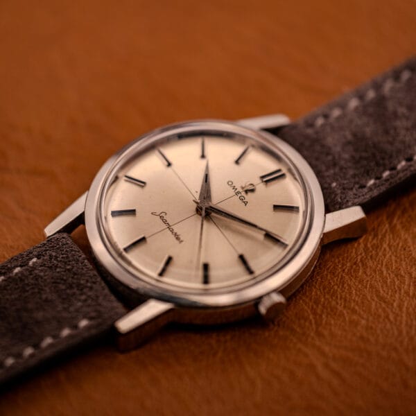 Omega Seamaster 135.005 angled view showing stainless steel case profile, downturned lugs, and original signed crown