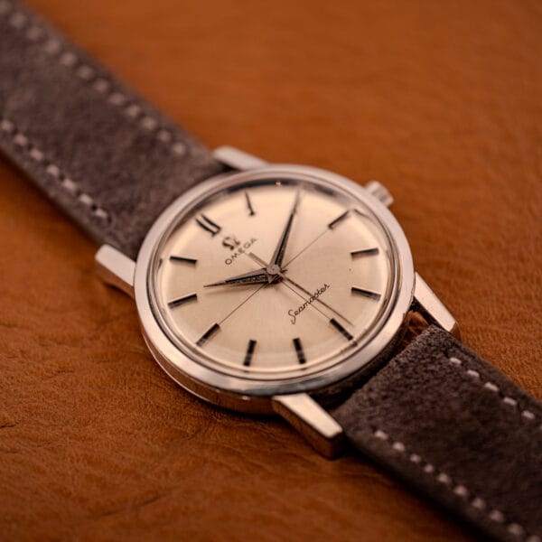 Omega Seamaster 135.005 cross-hair dial captured from a low angle on amber leather, gray suede strap underneath