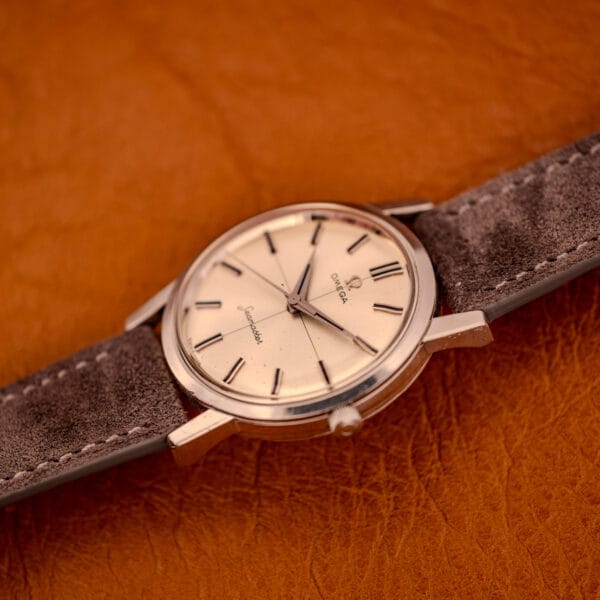 Omega Seamaster 135.005 from a steep angle showing case curvature, crown, and the cross-hair pattern across the silver dial