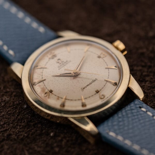 Omega Seamaster 2577-19 gold-capped case at an angle, faceted lugs and aged eggshell dial