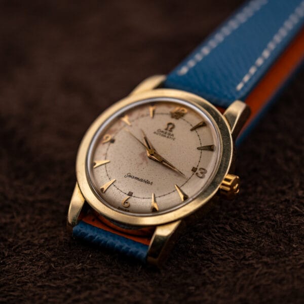 Omega Seamaster bumper 2577-19 gold-capped case on blue strap, angled three-quarter view