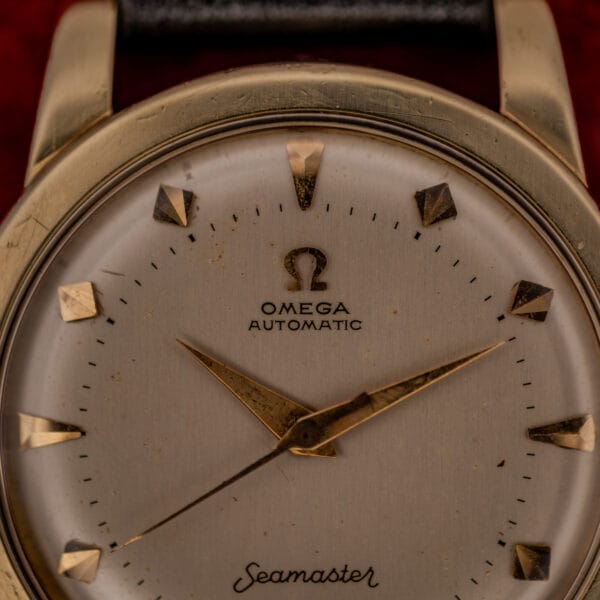 Omega Seamaster cream dial detail, Omega symbol over OMEGA AUTOMATIC printing with applied faceted gold dart hour markers