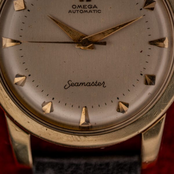 Omega Seamaster bumper dial lower half showing cursive Seamaster script, stepped minute track and gold dauphine hands