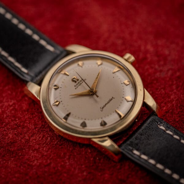 Omega Seamaster bumper automatic gold-cap case profile with two-tier cream dial and gold dauphine hands