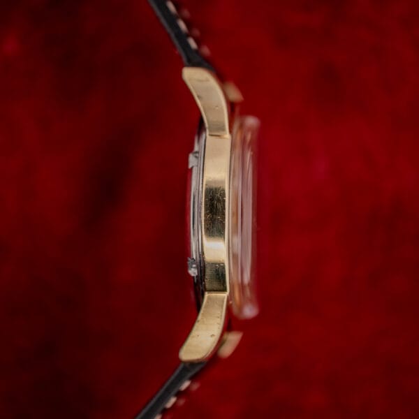 Omega Seamaster 2577-22 case side profile showing gold cap band, downturned lugs and domed acrylic crystal